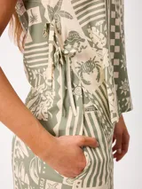 Top de algodón verde y crudo con estampado de motivos marinos, geométricos y tropicales, con tirantes anchos, escote cuadrado y cordones ajustables en los laterales.