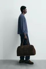 Camiseta de manga larga con cuello redondo y efecto lavado. Presenta un patrón de rayas horizontales finas en azul marino y blanco/beige.