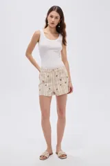 Short de algodón beige con diseño a rayas verticales y pequeño estampado de flores, con bolsillos laterales y cierre frontal con botón y cremallera.