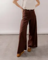 Pantalón wide leg de lino color marrón, de tiro alto con bolsillos traseros y frontales, cierre frontal con botón y bragueta.