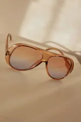 Lentes de sol de diseño envolvente con armazón de acetato negro y formato amplio tipo aviador con puente superior integrado.