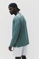 Remera deportiva de manga larga en tejido funcional con tecnología DryMove, diseñada para absorber el sudor y mantener la frescura durante el ejercicio. Presenta cuello redondo, corte estándar y aberturas laterales en el bajo.