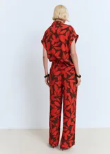 Pantalón largo de corte recto con estampado floral en tonos rojo y marrón, cuenta con cintura elástica y bolsillos laterales.