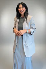 Blazer de corte sastre en color gris claro, con solapas clásicas, bolsillos frontales con solapa y mangas con detalle de frunce.