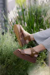 Sandalias de plataforma con diseño de tiras anchas en cuero marrón, cierre con velcro y suela de plataforma forrada en cuero al tono.