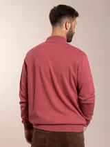 Campera color beige de tejido de punto con cierre frontal y cuello alto.