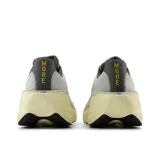 Championes de running New Balance modelo More V5, con tecnología Fresh Foam X en la entresuela para máxima amortiguación. Presentan un diseño de malla transpirable en color gris con detalles en turquesa y amarillo, y una suela voluminosa en tono crema.
