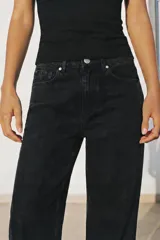 Jeans de tiro alto y corte recto de pernera larga, con diseño clásico de cinco bolsillos y costuras en contraste. Cierre frontal con cremallera y botón metálico.