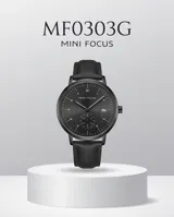 Reloj analógico de pulsera con caja redonda de metal negro, esfera minimalista con indicadores de hora, ventana de fecha y subesfera de segundos. Cuenta con correa de cuero negro y cierre de hebilla.