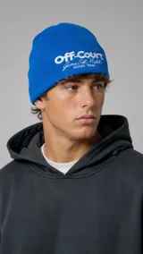Gorro de lana azul con vuelta y bordado frontal en color blanco con las inscripciones Off-Court, Game Set Match y Duxon Team.