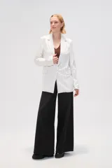 Blazer de viscosa a rayas verticales blancas y negras, con cuello solapa, cierre con botón y bolsillos delanteros.