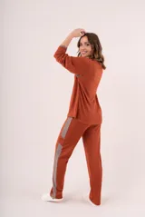 Conjunto de pijama color beige, compuesto por un buzo de manga larga con cuello redondo y un pantalón largo con cintura elástica.