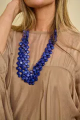Collar largo de múltiples hilos con cuentas circulares de resina en color azul.