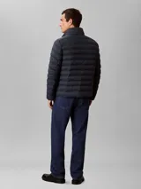 Campera puffer de peso medio Calvin Klein, con diseño acolchado, cuello alto y cierre frontal de cremallera. Presenta un logo sutil estampado en el pecho y está confeccionada en nailon reprocesado.
