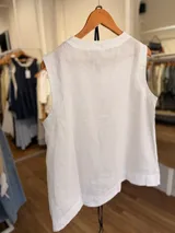 Blusa de lino color beige, sin mangas, con cuello redondo y silueta relajada. Incluye un cinturón fino desmontable de cuero negro.