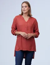 Blusa color ladrillo de crepe marca Cupio, con cuello a la base, escote en V y abertura con botones. Manga larga de largo regulable con presilla y botón. Largo de espalda mayor al largo delantero.