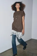 Vestido de punto marrón oscuro, sin mangas y cuello redondo, con un ruedo inferior de encaje blanco.