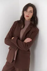 Blazer negro de poliéster, viscosa y spandex, con forro animal print, hombreras, botones frontales y en mangas.