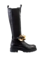 Bota de caña alta color negro, confeccionada en cuero, con elástico en los laterales y detalle de cadena dorada gruesa alrededor del tobillo.