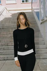 Camiseta de manga larga color gris melange, con cuello redondo y bajo recto. Presenta un detalle de tejido efecto doble a contraste en el cuello, puños y dobladillo inferior en color blanco.