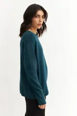 Sweater azul petróleo de tejido de punto, con cuello redondo y botones decorativos en los laterales.