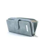 Billetera larga de cuerina color celeste con efecto desgastado, solapa con broche a presión y placa metálica con la marca grabada. Cuenta con compartimento posterior con cierre metálico.