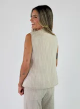 Chaleco sastrero sin mangas, de color beige con diseño de rayas verticales, cuello en V y cierre frontal con botones.