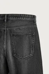 Jeans de denim de algodón en color azul con efecto desgastado, tiro medio y corte recto de ajuste holgado (loose fit). Cuenta con diseño clásico de cinco bolsillos y cierre frontal con cremallera y botón.