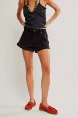 Short de denim negro de tiro medio y calce entallado, con cierre de botones a la vista, cinco bolsillos y ruedo con dobladillo vuelto.