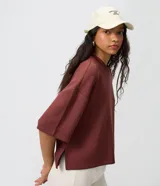 Remera de modal color crudo, con diseño minimalista, calce amplio, cuello redondo y mangas cortas amplias con hombros caídos.