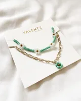 Set de collar y cadena dorada con dijes de flores de cuentas turquesas y blancas.