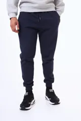 Pantalón de jogging de felpa en color azul marino, con cintura elástica ajustable mediante cordón y puños acanalados en los tobillos.