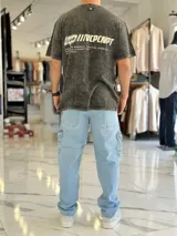 Remera oversize de color bordó con efecto gastado acid wash, mangas cortas y estampa en la espalda con texto y logo.