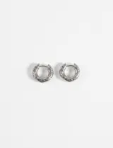 Aros tipo argolla gruesos con superficie texturada, fabricados en acero quirúrgico hipoalergénico de color plateado.