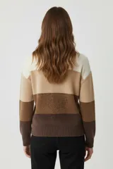 Sweater de punto con diseño de bloques de color en tonos tierra, cuello redondo a la base y mangas largas con puños acanalados.