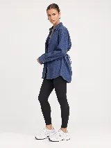 Camisa de denim azul con diseño oversize, cuello camisero, manga larga y cierre frontal de botones.