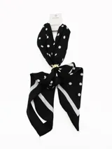 Pañuelo cuadrado de tela ligera color negro con estampado de lunares blancos y borde con franja blanca. Incluye un anillo metálico dorado para sujetar y estilizar el pañuelo.