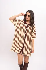 Vestido camisola de tejido de punto fresco, con rayas verticales en tonos marrones y beige, cuello polo marrón, mangas cortas y cierre frontal con botones de madera.