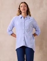Camisa celeste de lino marca Cable & Gauge, con cuello con solapa, abertura central con botones, bolsillos delanteros, mangas largas regulables con presilla y botón, y largo de espalda mayor al delantero.