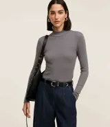 Blusa negra de rib de viscosa sostenible, con cuello alto y mangas largas.