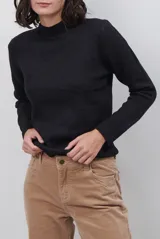 Polera de tejido de punto fino en color beige, con cuello alto y mangas largas con puños acanalados.