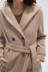 Tapado de paño color gris oscuro con solapas anchas, cierre frontal cruzado con botones y cinturón ajustable a la cintura. Posee mangas largas y bolsillos laterales.