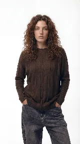 Sweater de punto con textura de ochos verticales, cuello redondo, mangas largas con puños acanalados y silueta relajada.