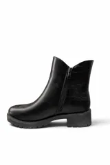 Botas cortas de cuero sintético color marrón, con suela track negra y detalle de textura símil cocodrilo en el lateral.
