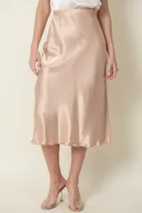 Pollera midi color marrón cobrizo de satén de seda, corte al bies y cintura elastizada.