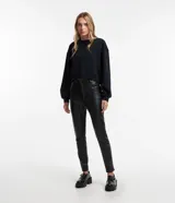 Pantalón skinny de cuero sintético negro, con trabillas en la cintura y bolsillos simulados.