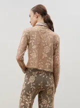 Camisa de encaje con diseño floral, de corte recto y manga larga, con cierre frontal de botones clásicos y cuello camisero.