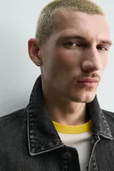 Cazadora de denim de algodón con corte regular fit, cuello solapa, cierre frontal con botones metálicos, mangas largas con puños abotonados y bolsillos laterales de vivo.