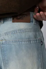 Jean de corte baggy con diseño amplio y holgado, confeccionado en denim de lavado claro con efecto desgastado en las piernas.