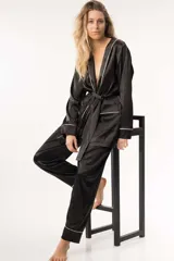 Pijama de satén negro con vivos blancos, compuesto por una bata con lazo y bolsillos, y un pantalón de corte recto con cintura elástica y bolsillos.